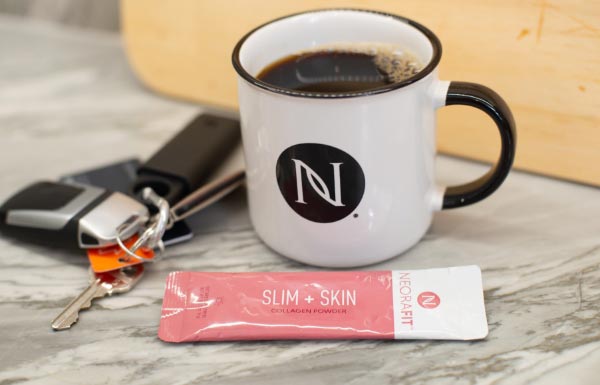 Lifestyle shot of NeoraFit™️ Slim & Skin next to a cup of coffee and car keys.